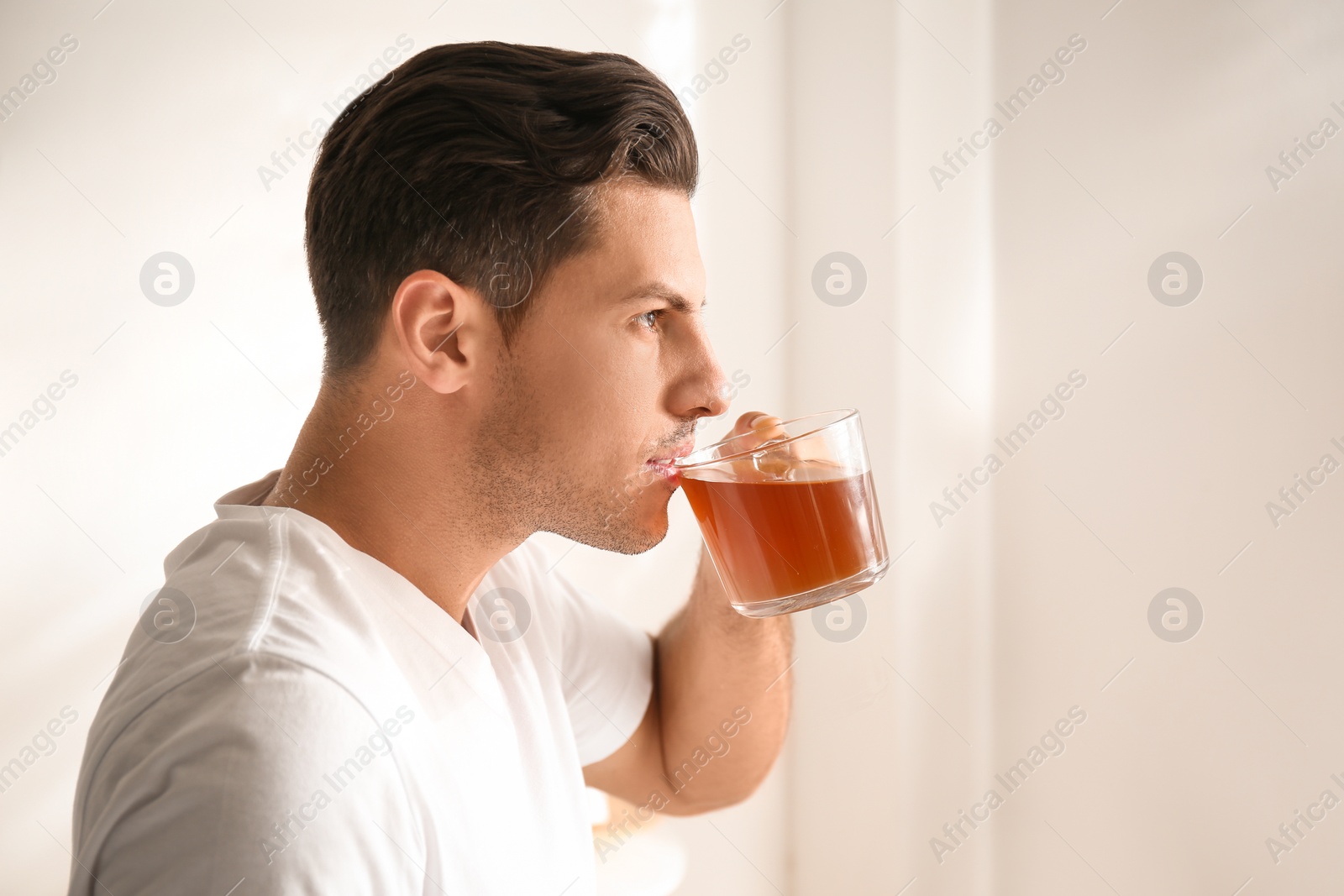 Photo of Man with cup of tea indoors. Lazy morning
