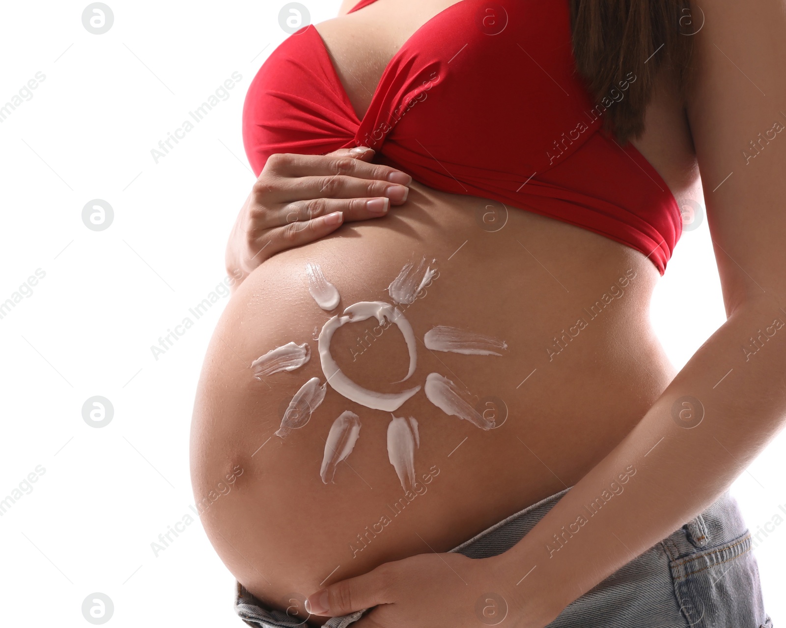 Photo of Young pregnant woman with sun protection cream on belly against white background, closeup