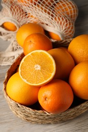 Photo of Many whole and cut oranges on wooden table