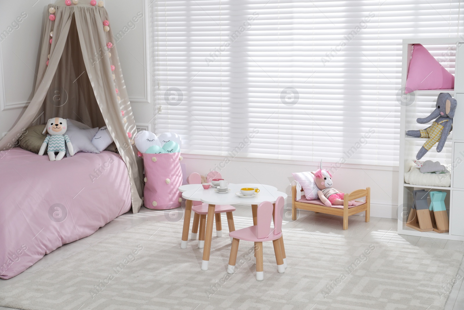 Photo of Cute child's room interior with toys and modern furniture