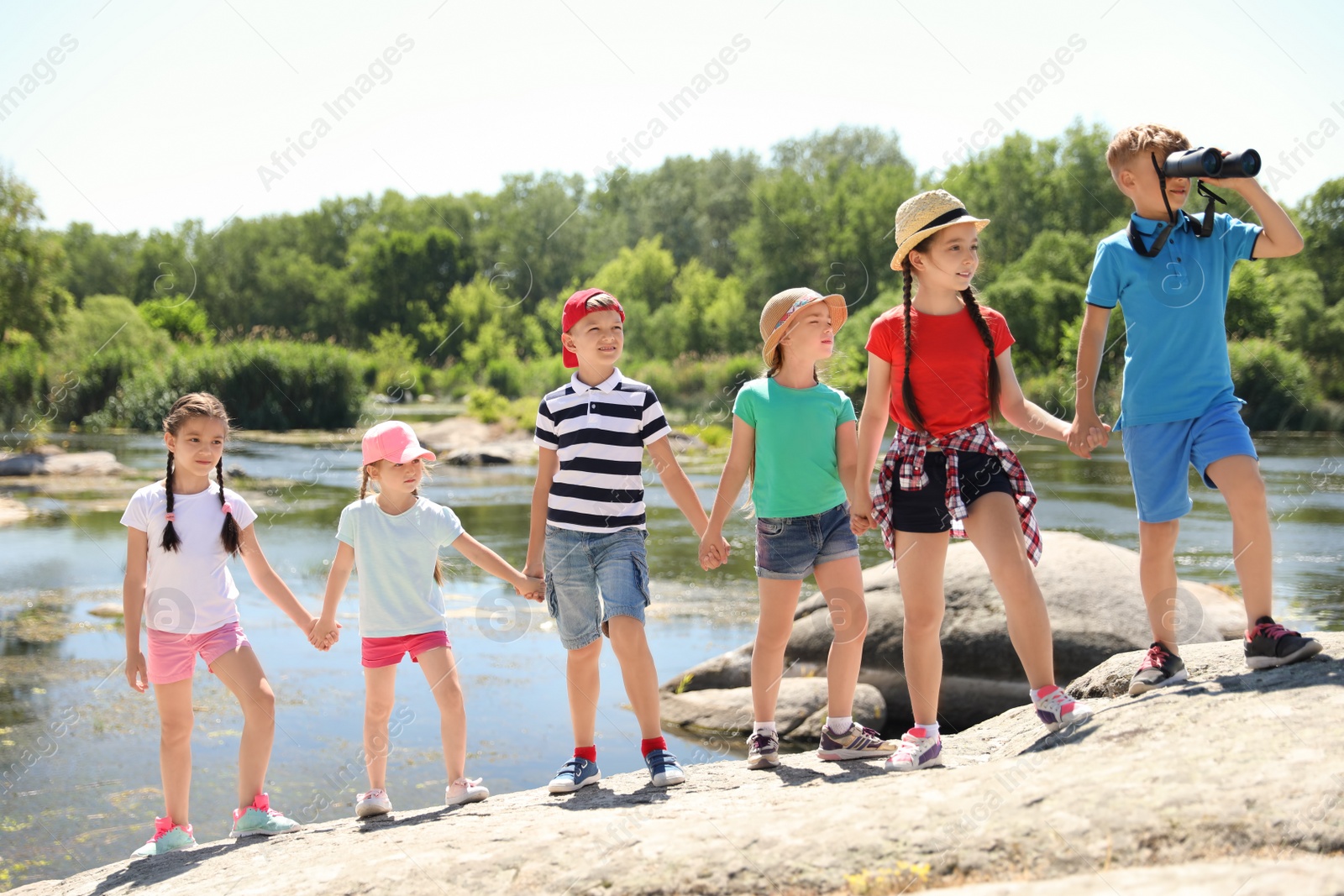 Photo of Little children with binoculars outdoors. Summer camp