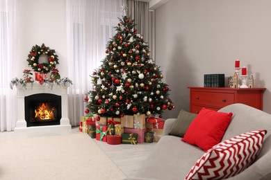 Beautiful Christmas tree and gifts near fireplace in festively decorated living room