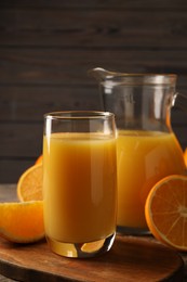 Tasty fresh oranges and juice on wooden table, closeup