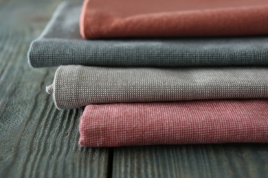 Different colorful napkins on wooden table, closeup