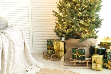 Photo of Many different gifts under Christmas tree indoors