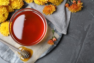 Flat lay composition with organic honey on dark grey table