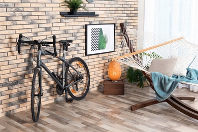 Photo of Modern bicycle and hammock in stylish room interior