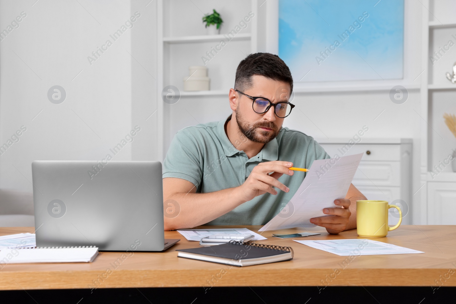 Photo of Man doing taxes at table in room