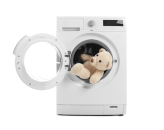 Photo of Modern washing machine with teddy bear on white background. Laundry day