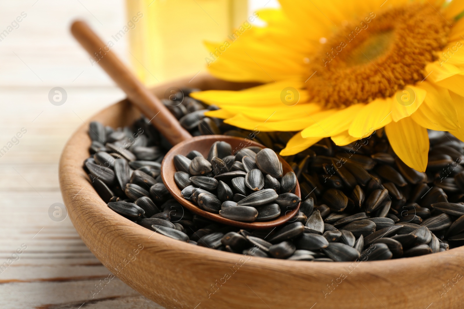 Photo of Bowl and spoon with sunflower seeds, closeup