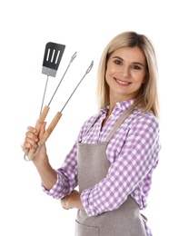 Woman in apron with barbecue utensils on white background