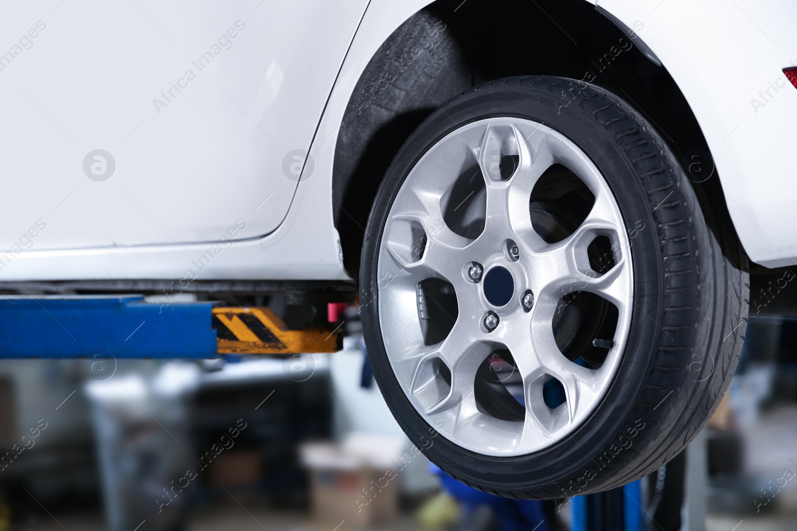 Photo of Car on lift at tire service, closeup