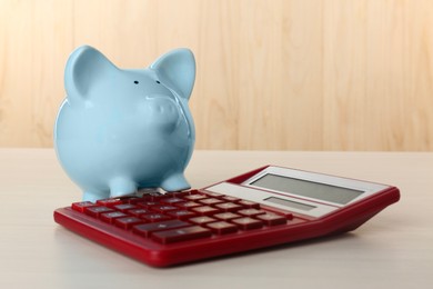 Calculator and piggy bank on light table