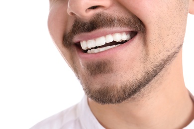 Photo of Young man with healthy teeth smiling on white background, closeup