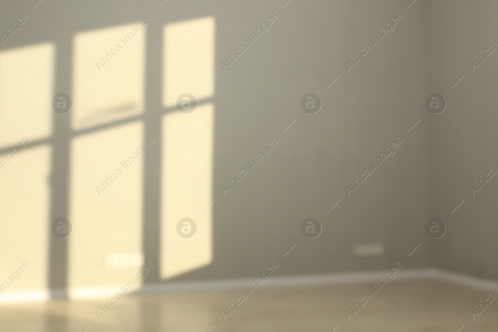 Photo of Blurred view of light and shadows from window on wall indoors