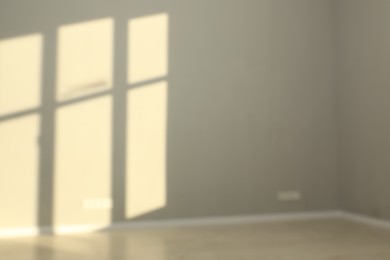 Photo of Blurred view of light and shadows from window on wall indoors