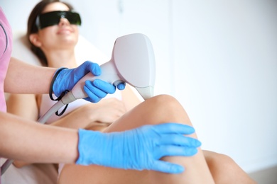 Young woman undergoing laser epilation procedure in beauty salon