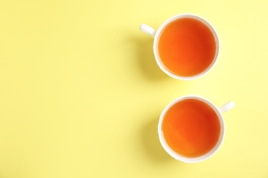 Photo of Cups of delicious tea on color background, top view