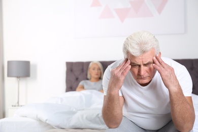 Senior man having conflict with his wife in bedroom. Relationship problems