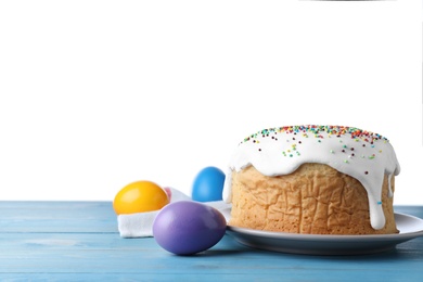 Photo of Easter cake and color eggs on blue wooden table, space for text