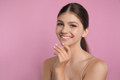 Photo of Portrait of pretty girl on pink background, space for text. Beautiful face with perfect smooth skin