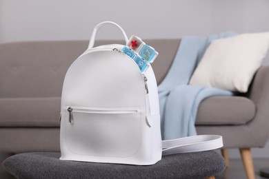 Photo of Stylish women's backpack with plastic pill box in room