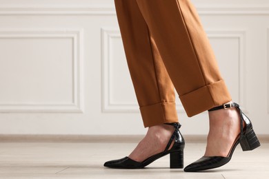 Photo of Businesswoman in elegant leather shoes indoors, closeup. Space for text