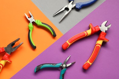 Photo of Different pliers on color background, flat lay