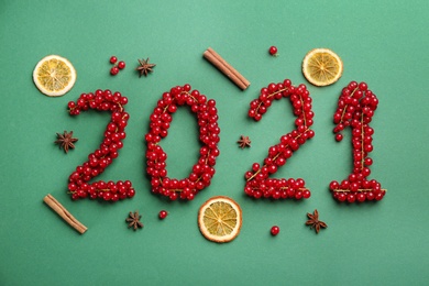 Photo of 2012 made of cranberries on green background, flat lay