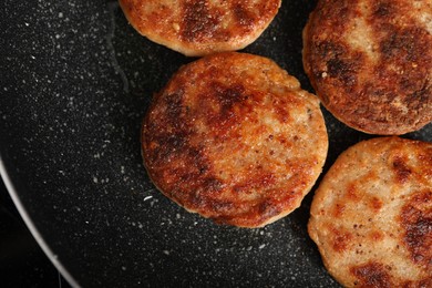 Photo of Cooking vegan cutlets in frying pan, top view