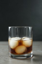 Delicious cocktail with ice balls on grey table, space for text