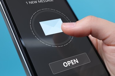 Image of Got new message. Woman using smartphone on light blue background, closeup