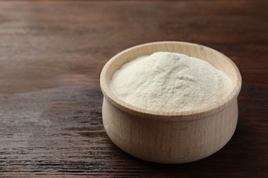 Photo of Bowl of agar-agar powder on wooden table, closeup. Space for text