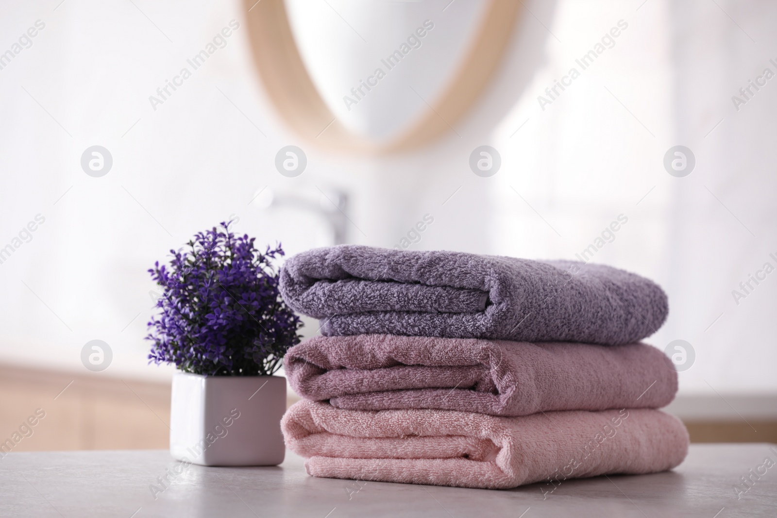 Photo of Stack of fresh towels on table in bathroom