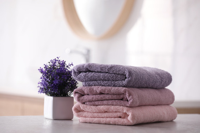 Photo of Stack of fresh towels on table in bathroom