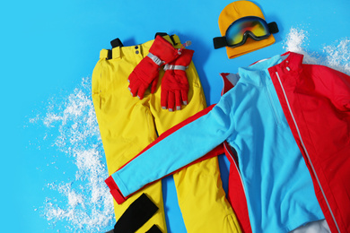 Photo of Stylish winter sport clothes on light blue background, flat lay