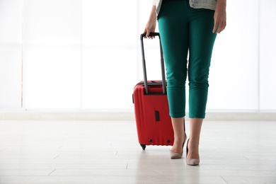 Photo of Businesswoman with red travel suitcase in airport. Space for text