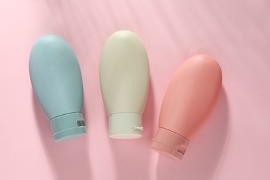Photo of Cosmetic travel kit on pink background, top view