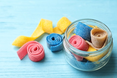 Photo of Jar of delicious chewing candies on wooden table