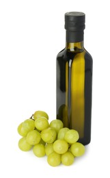 Photo of Vegetable fats. Bottle of cooking oil and fresh grapes isolated on white