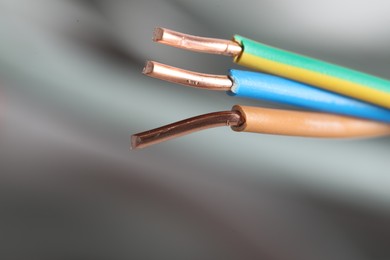 Photo of Colorful electrical wires on blurred background, closeup. Space for text
