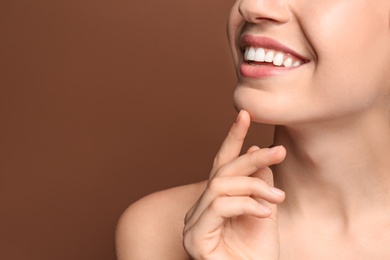 Photo of Young woman with beautiful smile on color background. Teeth whitening