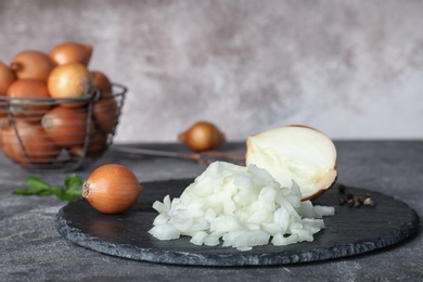 Photo of Slate plate with cut onion on table