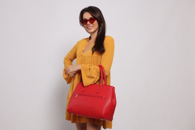 Photo of Young woman with stylish bag on white background