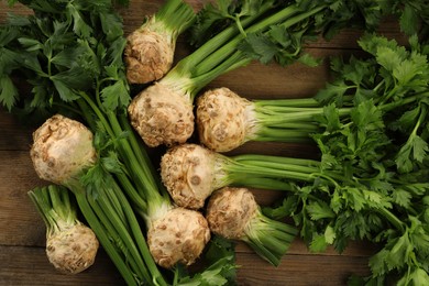 Photo of Fresh raw celery roots on wooden table, flat lay