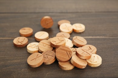 Photo of Pile of runes with different symbols on wooden table