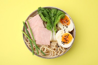 Photo of Delicious ramen with meat on pale yellow background, top view. Noodle soup