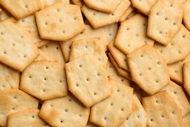 Photo of Many delicious crackers as background, top view