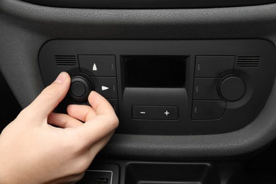 Woman adjusting air conditioner in car, closeup