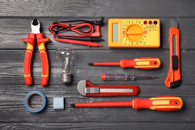 Photo of Flat lay composition with electrician's tools on wooden background